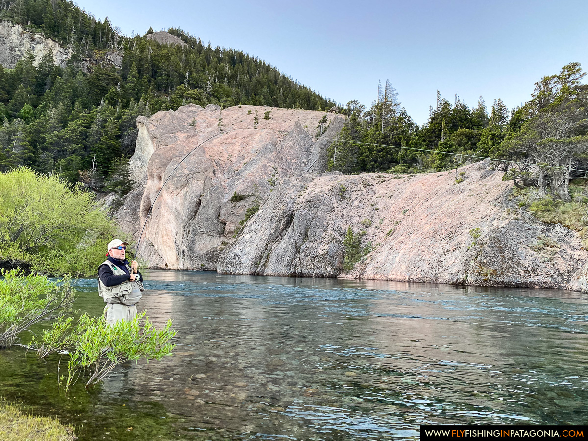 Fly angler casting beneath the cliffs of the Traful River