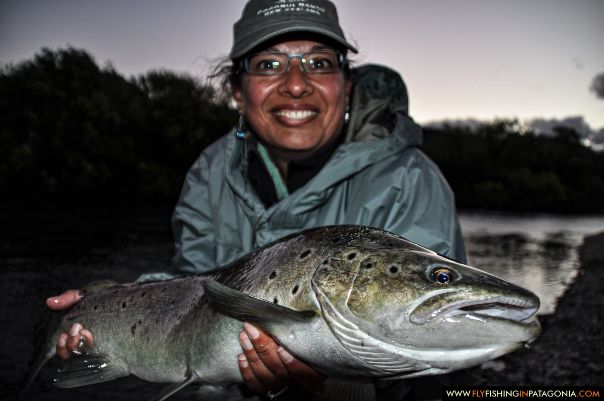 Woman holding a trophy wild trout from the Traful River